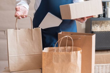 Bir sürü kağıt torba ve kutu Packer 'ın yanında kalıyor. Müşteri Teslimat Hizmeti Paketleme Emri.