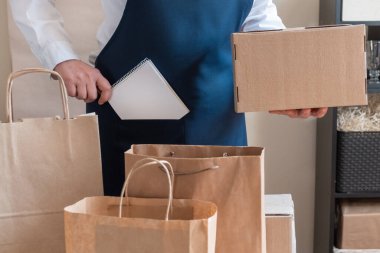 Bir sürü kağıt torba ve kutu Packer 'ın yanında kalıyor. Müşteri Teslimat Hizmeti Paketleme Emri.