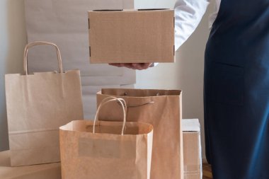 Bir sürü kağıt torba ve kutu Packer 'ın yanında kalıyor. Müşteri Teslimat Hizmeti Paketleme Emri.