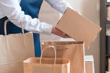 Bir sürü kağıt torba ve kutu Packer 'ın yanında kalıyor. Müşteri Teslimat Hizmeti Paketleme Emri.