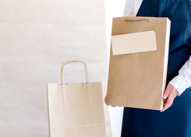 Bir sürü kağıt torba ve kutu Packer 'ın yanında kalıyor. Müşteri için Üniformalı Paketleme Hizmeti Teslimat Servisi.