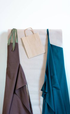 Kağıt torbalar ve duvarda iki önlük. Müşteri için Üniforma Teslimat Servisi.