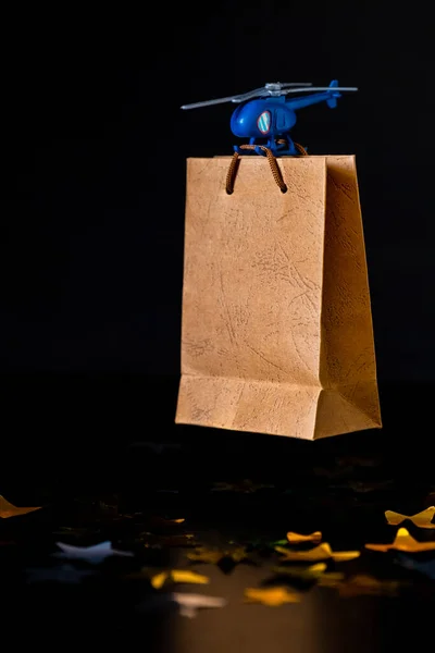 Blue Toy Helicopter Delivers Gift Paper Bag. Father\'s day, Birthday concept.