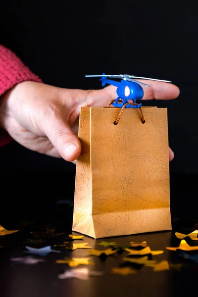 Blue Toy Helicopter Delivers Gift Paper Bag. Father\'s day, Birthday concept.