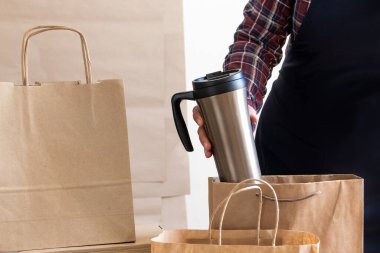 Bir sürü Craft Kese kağıdı ve Kutusu elinde bir fincan kahveyle Packer 'ın yanında duruyor. Müşteri Teslimat Hizmeti Paketleme Emri.