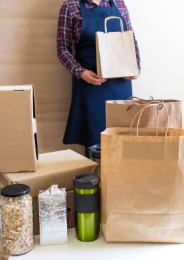 Bir sürü kağıt torba ve kutu Packer 'ın yanında kalıyor. Müşteri Teslimat Hizmeti Paketleme Emri.