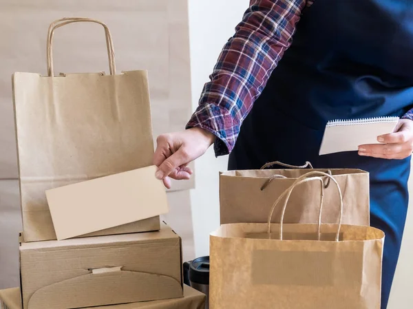 Bir sürü kağıt torba ve kutu Packer 'ın yanında kalıyor. Müşteri Teslimat Hizmeti Paketleme Emri.