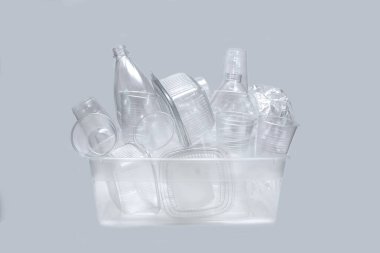 Beyaz arka planda bir sürü plastik kap ve kap var. Çevrenin korunması kavramı.
