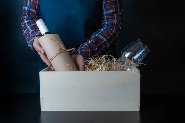 Teslimat İşçisi Şarap Şişesi ve Bardakları paketliyor. Müşteri için samanla kutulamak üzere..