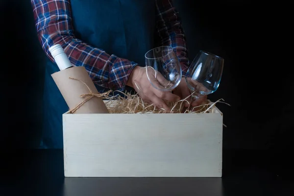 Worker of Delivery Service Packing Wine Bottle and Glasses to box with straw for Customer.