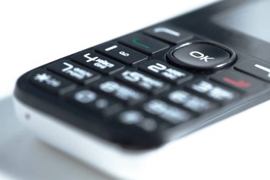 Beyaz arkaplandaki eski düğmeli telefon. 