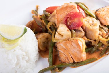 Bir ızgara, pirinç ve bir dilim limon hazırlanan sebzeli balık