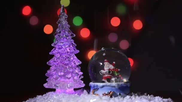 Санта и его помощник снеговик в стеклянном шаре зачитывают список подарков для детей на рождественский праздник — стоковое видео