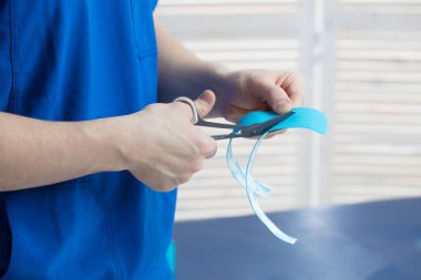 Doktor, genç bir kız için omurgayı bantlama prosedürünü uyguluyor.