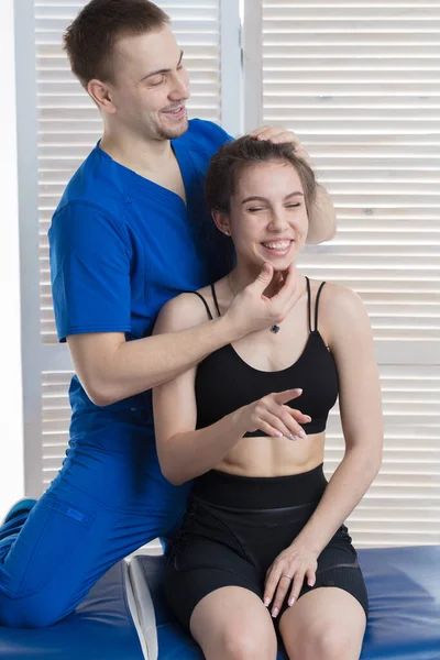 Doktor genç bir kızın kafa ve boyun omurgasına teşhis koyuyor. Masaj ve manuel terapi