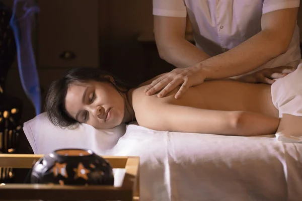 Beautiful girl in a massage parlor for back health treatments and aromatherapy