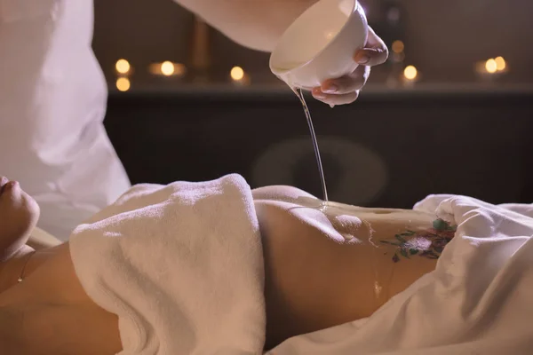 Güzel bir kız midesinde hindistan cevizi yağıyla sağlık tedavisi görüyor.