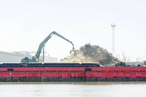 При завантаженні і розвантаженні металобрухту порту на баржі Стокова Картинка