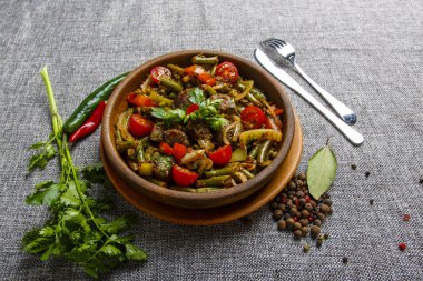 Kil tabakta sebzeli tavuk ciğeri. Karaciğer, soğan, fasulye, domates parçaları.. 