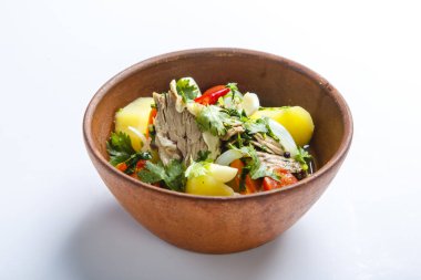 Kil tabakta Hashlama. Bileşenler: Sığır kaburgası, patates, otlar, sarımsak.