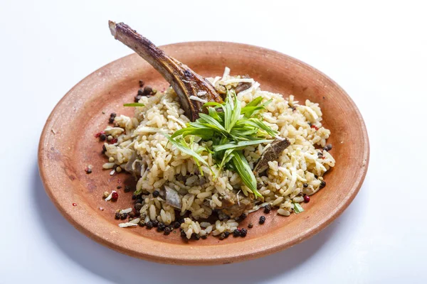 Costilla de cordero con arroz en un plato de barro —  Fotos de Stock