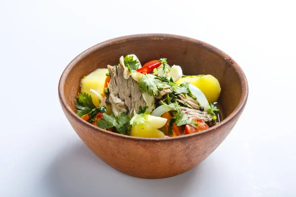 Kil tabakta Hashlama. Bileşenler: Sığır kaburgası, patates, otlar, sarımsak.