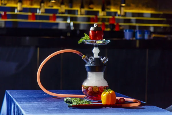 Hookah en verduras. El frasco de Hookah contiene verduras picadas: pimienta, pepino, rábanos, hierbas. Las verduras están llenas de licor rojo. Cuenco de narguile de pimienta roja. Mucho humo. . — Foto de Stock