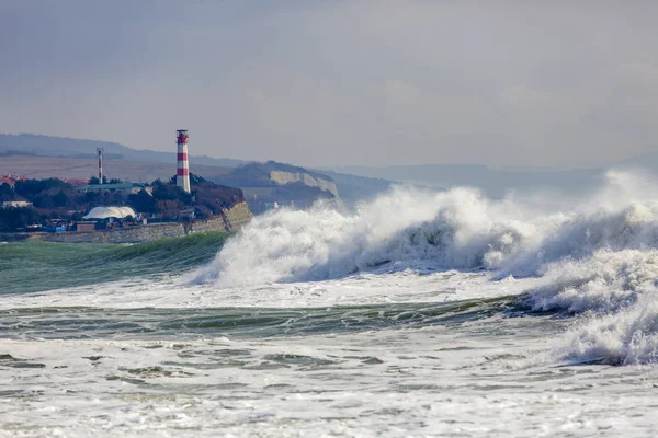 Hermosas olas de tormenta en la entrada de la bahía de Gelendzhik. En el fondo, la torre del faro en un empinado Banco empinado . —  Fotos de Stock