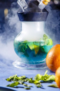 Portakallı nargile. Portakallı nargile. Portakal ve nane dilimlenmiş şeffaf bir matara ile nargile. Nargile kasesi birbirine bağlı çeşitli portakallardan yapılmıştır..