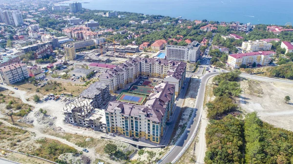 Vários edifícios do complexo residencial já estão prontos Uma casa está em construção. No meio de um parque residencial copmlete. No fundo mar, Baía — Fotografia de Stock