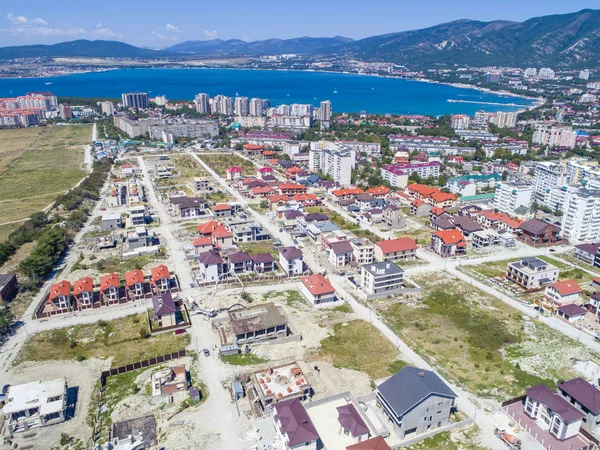 Construction of cottages in the seaside town.  Houses on the shore of Gelendzhik Bay. Aerial view.