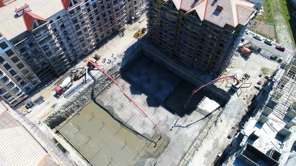 Construcción de un complejo residencial de varios pisos. Vista aérea. Verter concreto Fundación de uno de los edificios . —  Fotos de Stock