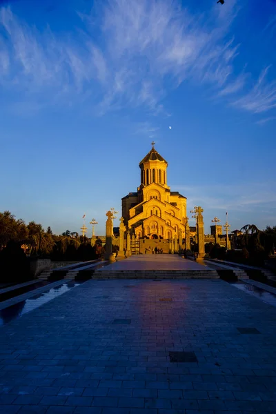 トビリシ冬の写真聖三位一体大聖堂(tsminda Sameba)はジョージアの主な教会です。オレンジの明るい夕日が大聖堂を照らす — ストック写真