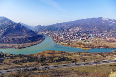 Gürcistan, Mtskheta, Kura ve Aragvi nehirlerinin birleştiği yer, çamurlu ve temiz bir nehir. Jvari manastırının manzarası. Kafkas dağları, manastırlar. 