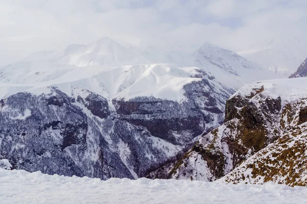 Snow-capped mountain peaks and deep gorges in the area of cross pass, Georgia. Fog, clouds, snow