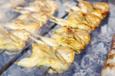 Izgarada bıldırcın. Birkaç bıldırcın bir şişe bağlanır ve kömürde kızartılır..