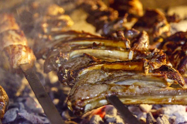 Ruddy et appétissant rôti de côtes levées sur le gril à côté de la viande et des pommes de terre — Photo