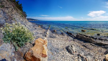 Rocks with a black hue on the black sea coast on a clear Sunny day