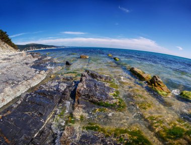 Rocks with a black hue on the black sea coast on a clear Sunny day