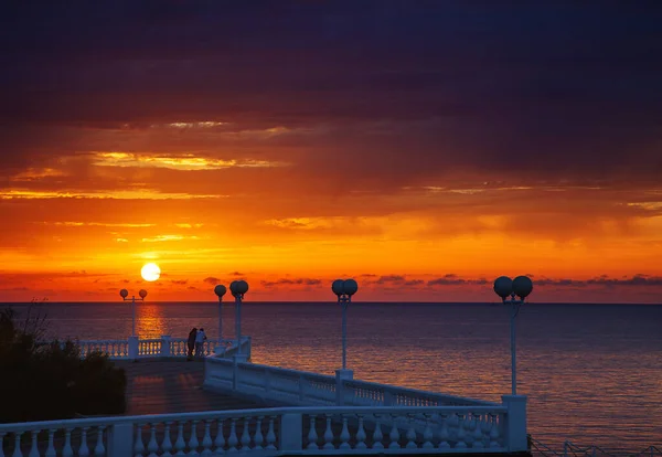 Remblai de Gelendzhik au coucher du soleil. Balustrade sur fond de soleil au coucher du soleil. Coucher de soleil rouge vif, rouge-noir — Photo