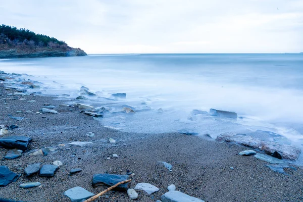 Stormvloeden bij lage sluitertijd op een kiezelstrand, het resort Gelendzhik, de schemering — Stockfoto