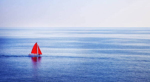 A ship with scarlet sails sails on a blue sea on a summer day