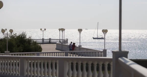 Promenade met balustrade op de achtergrond van de zee, jacht op een heldere zonnige dag. — Stockfoto