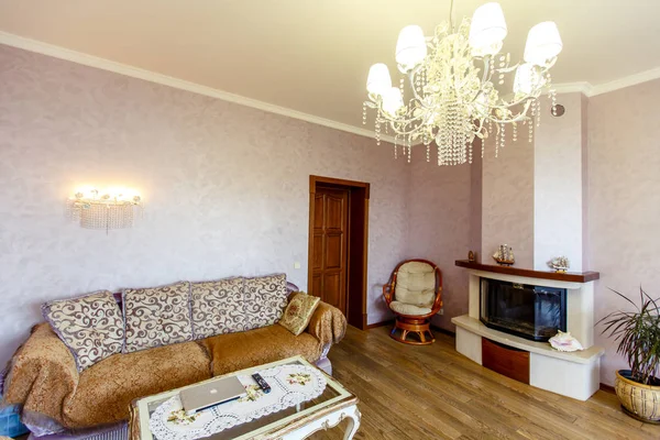 Кімната в класичному стилі з каміном, диваном, журнальним столиком і стільцем у кутку . — стокове фото
