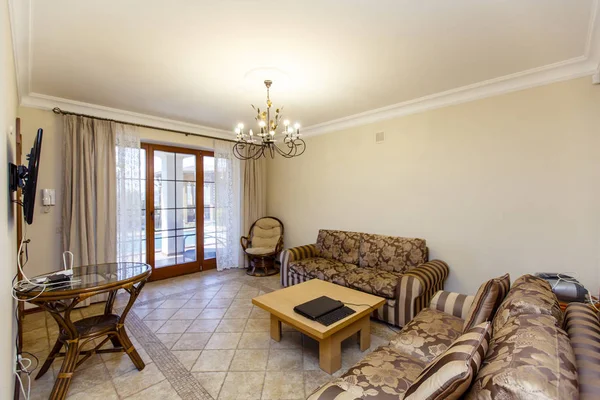 İki kahverengi çizgili kanepesi ve kahve masası olan bej renkli bir oda. — Stok fotoğraf