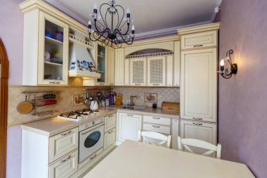 Lüks zengin, modern bej mutfak Provence tarzı, pembe duvar, sahte siyah avize.