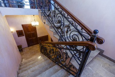 Kulübedeki merdivenler demir parmaklıklar ve ahşap parmaklıklarla döşenmiş. Mermer adımlar. 