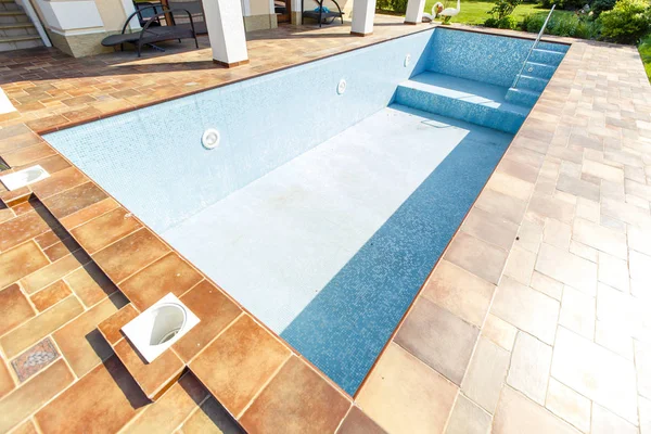 Kulübenin arka bahçesinde susuz bir havuz.