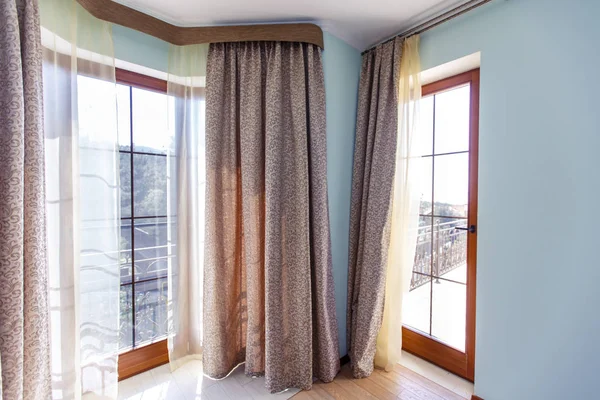 Janelas grandes com cortinas. As paredes são azuis. Cortinas castanhas — Fotografia de Stock