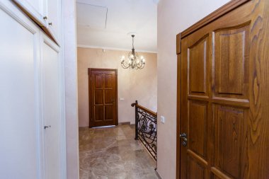 Kulübedeki merdivenler. Mermer merdivenler, işlenmiş demir parmaklıklar, tahta korkuluklar. Demir işlemeli avize. İskelede ahşap kapı.